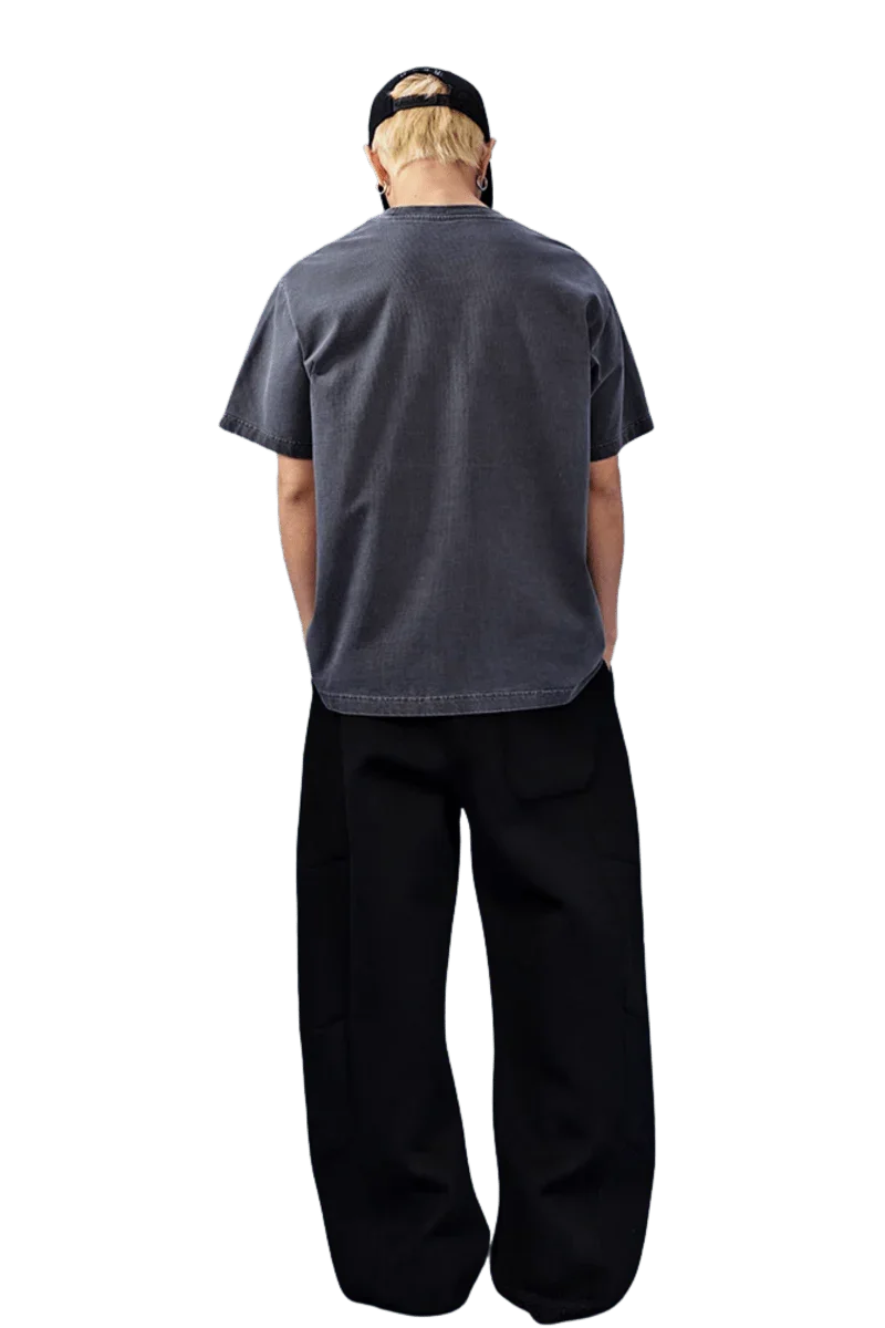 Back view of a gray MEDM SS25 Basic Logo Washed Tee styled with relaxed black pants