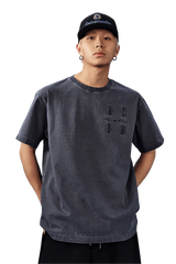 Model wearing MEDM SS25 Basic Logo Washed Tee in dark gray with a relaxed fit and unique design