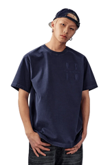 Model wearing the MEDM SS25 Basic Logo Washed Tee in navy blue, styled casually with jeans