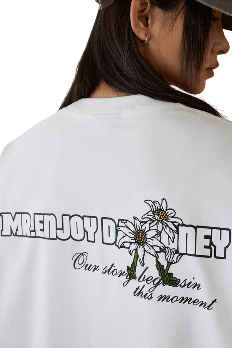 MEDM SS25 Big M Daisy Print Tee with floral design and slogan on the back