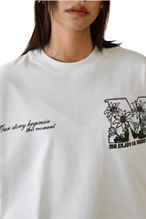 MEDM SS25 Big M Daisy Print Tee featuring floral design and stylish quotes on a white background