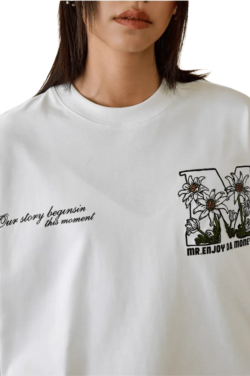 MEDM SS25 Big M Daisy Print Tee featuring floral design and stylish quotes on a white background