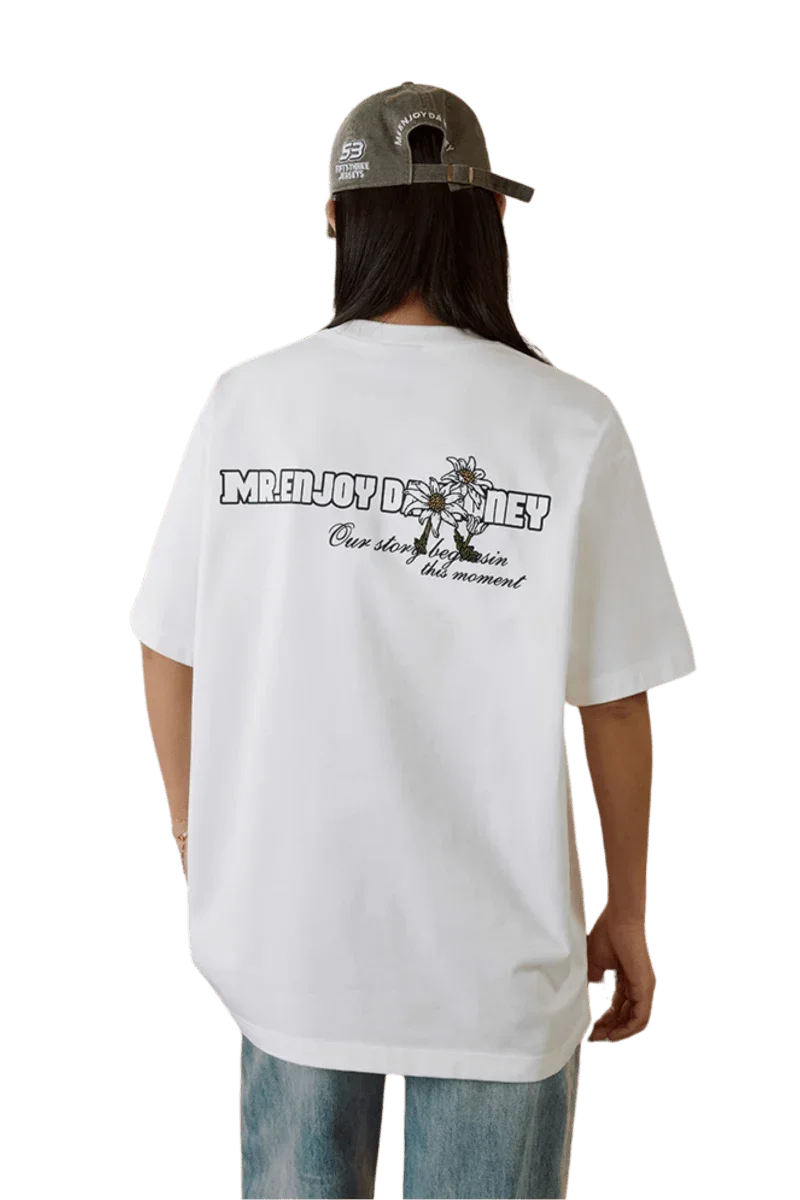 MEDM SS25 Big M Daisy Print Tee in white with graphic design on the back from Mr Enjoy Da Money