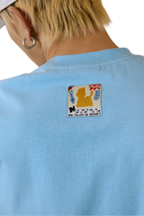 Back view of MEDM SS25 Cat Velcro Embroidery Tee in light blue featuring a unique embroidered patch