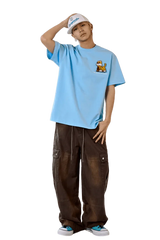 Model wearing MEDM SS25 Cat Velcro Embroidery Tee in blue with casual baggy pants