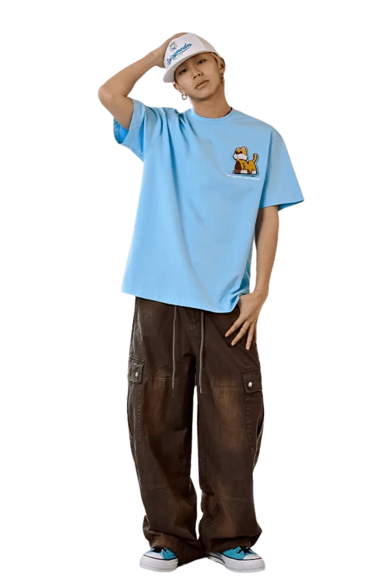 Model wearing MEDM SS25 Cat Velcro Embroidery Tee in blue with casual baggy pants