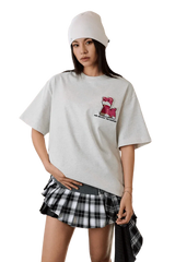 Casual outfit featuring the MEDM SS25 Cat Velcro Embroidery Tee with stylish layering and a plaid skirt