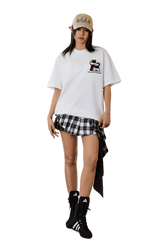 MEDM SS25 Cat Velcro Embroidery Tee in white paired with a plaid skirt and stylish accessories