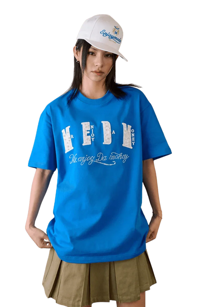 MEDM SS25 Chanel Inspired Patch Pearl Tee in vibrant blue, worn with a stylish cap for a trendy look