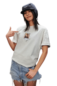 Model wearing a grey MEDM SS25 Dog Polaroid Tee with a vintage photo print, styled with denim shorts