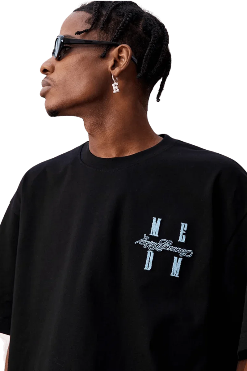 Model wearing MEDM SS25 Felt Embossed Basic Tee in black with stylish design and casual fit