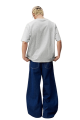 Model wearing MEDM SS25 Felt Embossed Basic Tee in gray from the back with loose-fit jeans