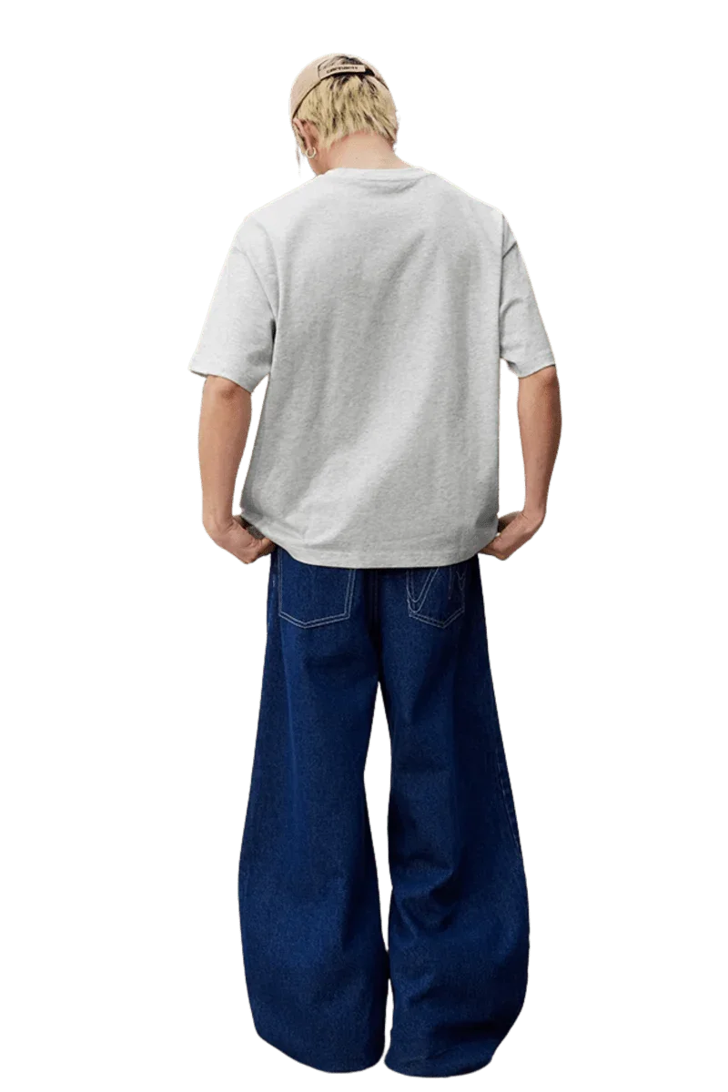Model wearing MEDM SS25 Felt Embossed Basic Tee in gray from the back with loose-fit jeans