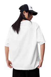 Back view of a model wearing the MEDM SS25 Felt Embossed Basic Tee in white with a cap
