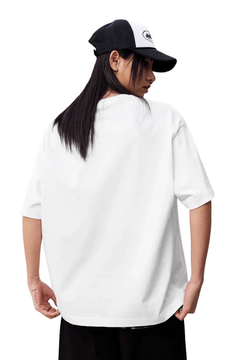 Back view of a model wearing the MEDM SS25 Felt Embossed Basic Tee in white with a cap