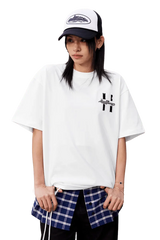 Model wearing a white MEDM SS25 Felt Embossed Basic Tee layered over a plaid shirt