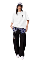 Model wearing the MEDM SS25 Felt Embossed Basic Tee with plaid shirt and relaxed pants