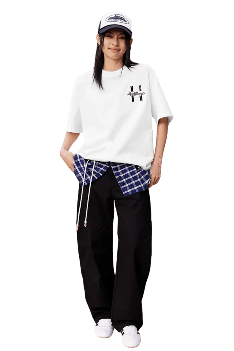 Model wearing the MEDM SS25 Felt Embossed Basic Tee with plaid shirt and relaxed pants