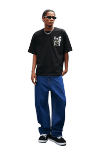 Model wearing MEDM SS25 Floral Embroidery Tee in black with jeans and sneakers, showcasing casual streetwear style.