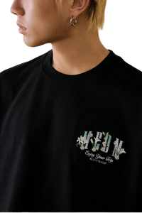 Close-up of the MEDM SS25 Floral Felt Embossed Tee featuring vibrant floral embroidery on a black shirt