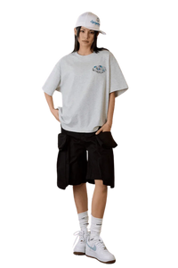 Model wearing MEDM SS25 Floral Felt Embossed Tee with cargo shorts and sneakers for a casual look