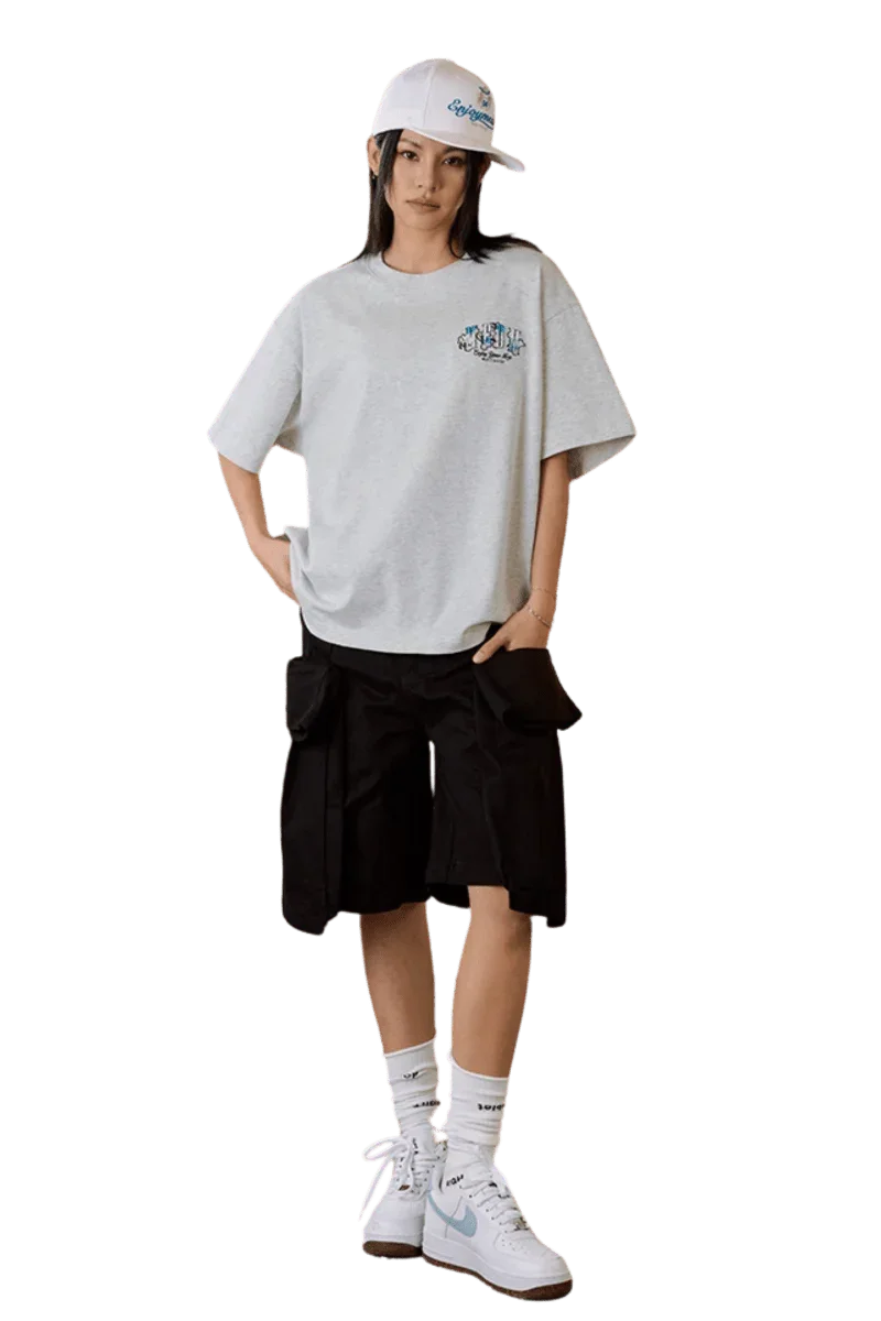 Model wearing MEDM SS25 Floral Felt Embossed Tee with cargo shorts and sneakers for a casual look