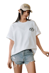 Model wearing MEDM SS25 Floral Felt Embossed Tee with denim shorts and a stylish cap