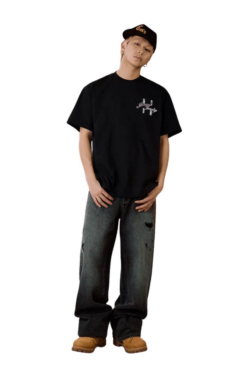 Model wearing MEDM SS25 Four Color Velvet Embossed Tee with relaxed fit and black distressed jeans