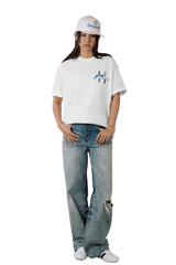 Model wearing MEDM SS25 Four Color Velvet Embossed Tee paired with light blue jeans and a cap