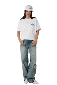 Model wearing MEDM SS25 Four Color Velvet Embossed Tee paired with light blue jeans and a cap