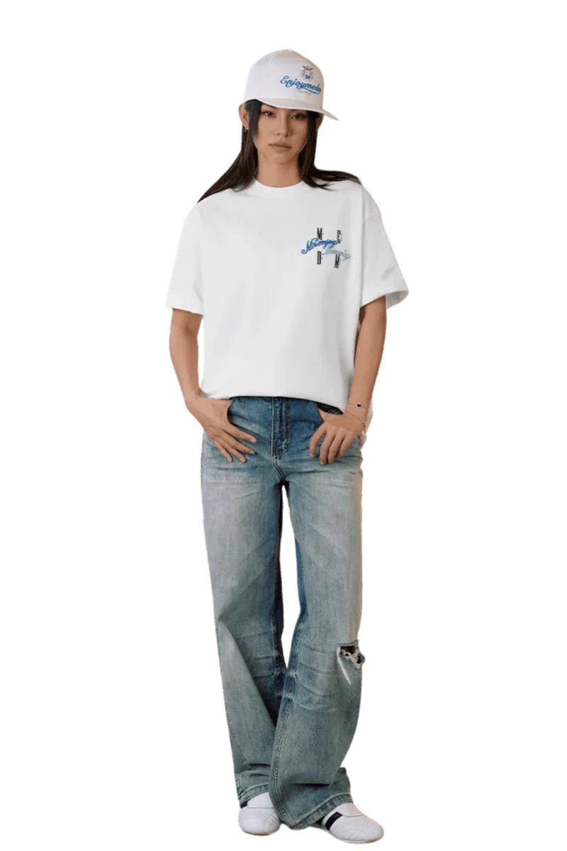Model wearing MEDM SS25 Four Color Velvet Embossed Tee paired with light blue jeans and a cap