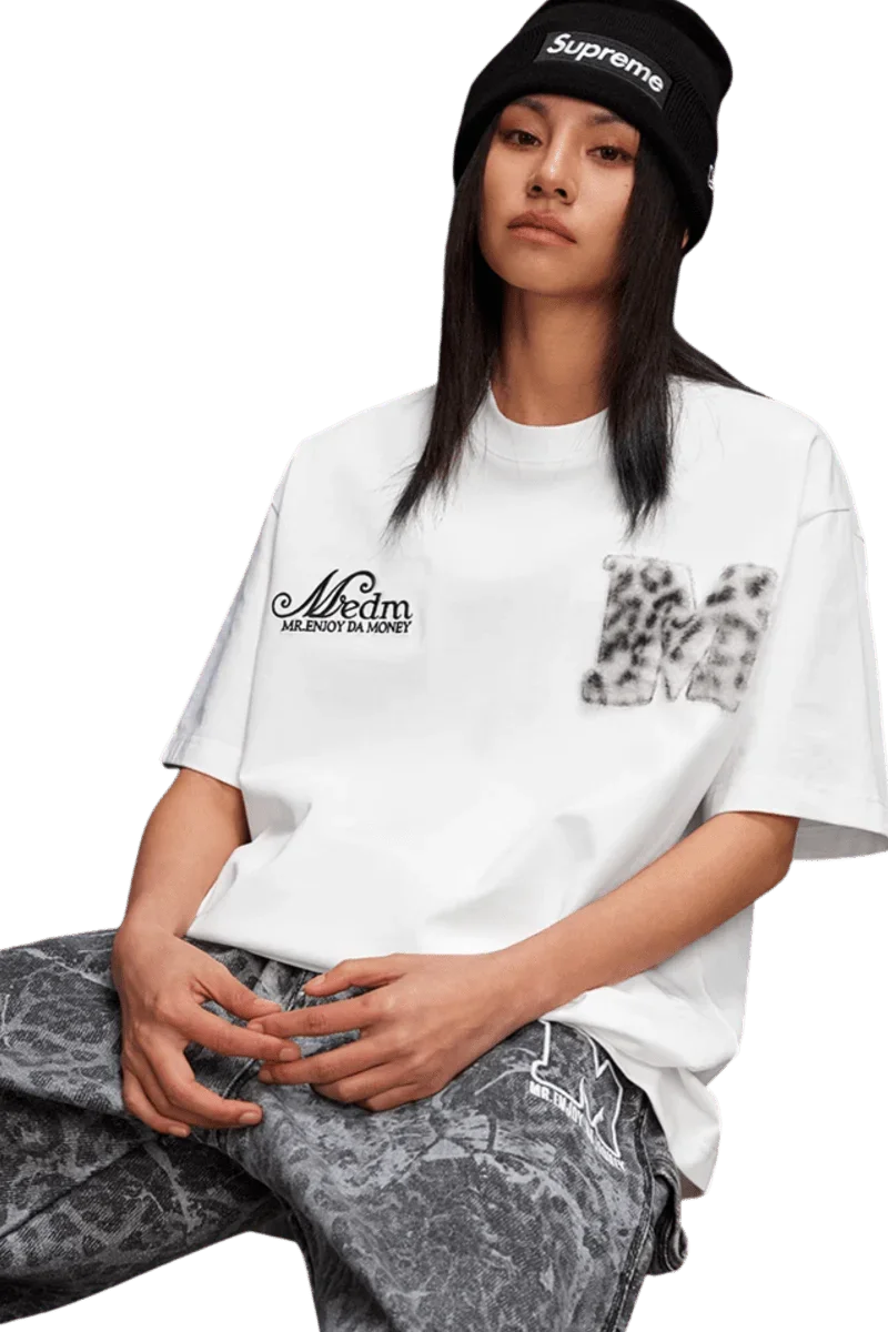 Mr Enjoy Da Money MEDM SS25 Leopard Fur Big M Tee in white, worn with stylish gray patterned pants