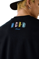 Black MEDM SS25 Macaron Velvet Embossed Tee featuring colorful logo on the back for a trendy look