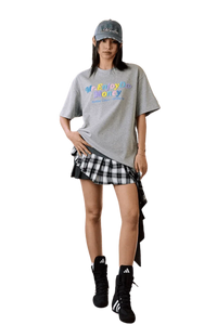 Model wearing MEDM SS25 Macaron Velvet Embossed Tee with a plaid skirt and accessories