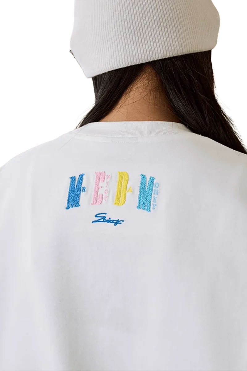 Back view of the MEDM SS25 Macaron Velvet Embossed Tee in white with colorful logo details