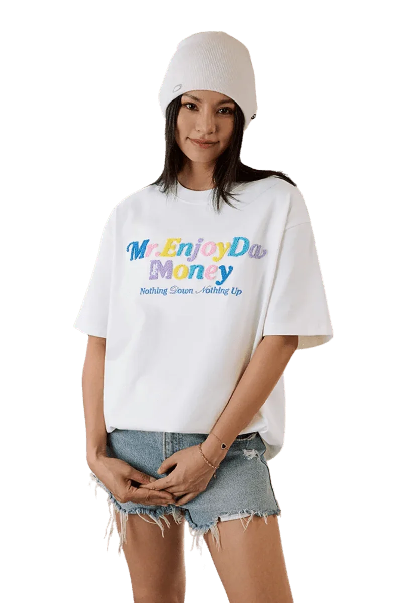 Model wearing MEDM SS25 Macaron Velvet Embossed Tee in white with colorful text and casual shorts