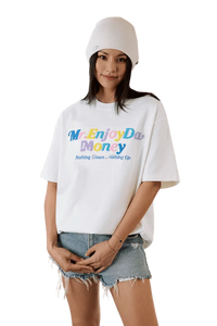 Model wearing MEDM SS25 Macaron Velvet Embossed Tee in white with colorful text and casual shorts