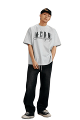Model wearing MEDM SS25 Serendipity Embroidery Tee with casual baggy jeans and sneakers