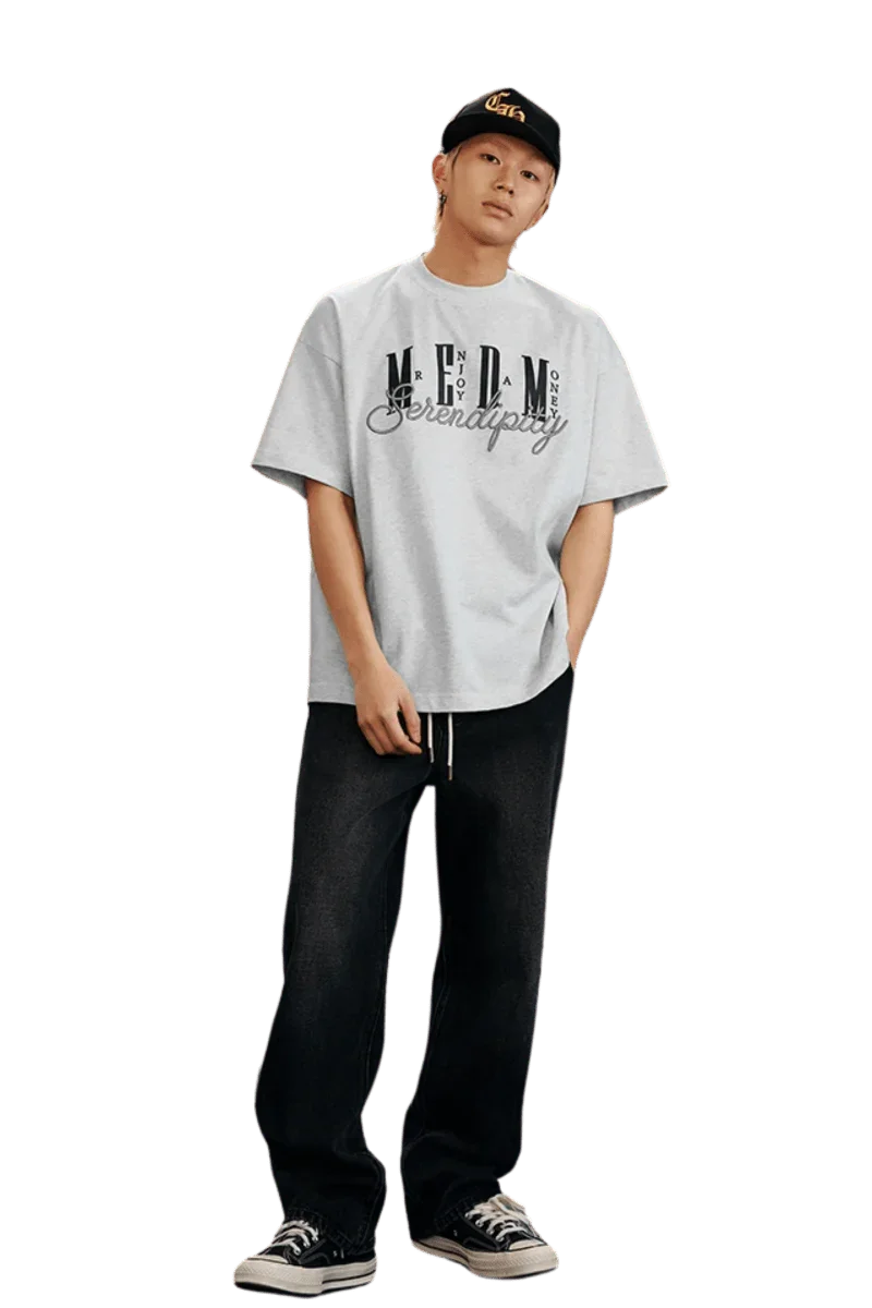 Model wearing MEDM SS25 Serendipity Embroidery Tee with casual baggy jeans and sneakers