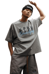 Model wearing the MEDM SS25 Serendipity Embroidery Tee in grey with stylish oversized fit