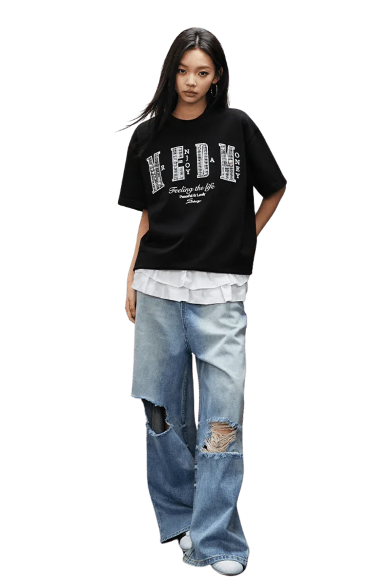 Model wearing MEDM SS25 Small Pearl Tee in black over a white shirt with distressed jeans for a casual look