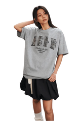 Model wearing the MEDM SS25 Small Pearl Tee in gray with a stylish oversized fit