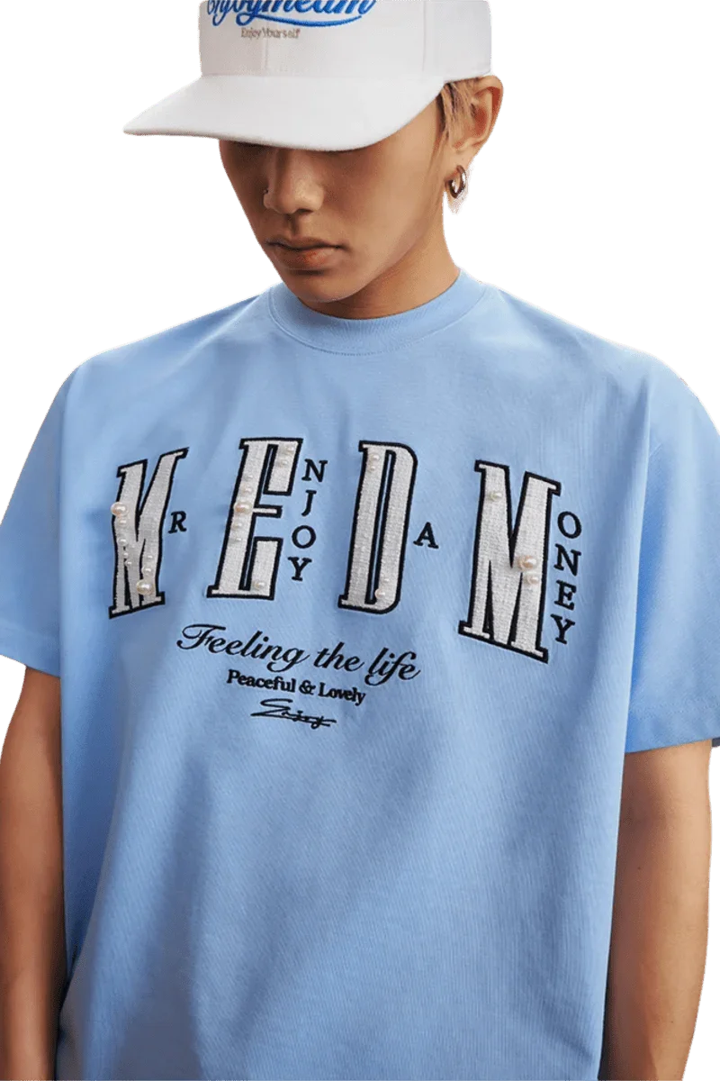 MEDM SS25 Small Pearl Tee in light blue featuring unique lettering and comfortable fit for casual wear