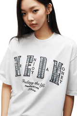 Model wearing MEDM SS25 Small Pearl Tee in white with graphic print and oversized fit