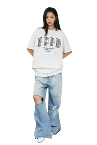 Model wearing MEDM SS25 Small Pearl Tee with distressed jeans for a trendy casual look