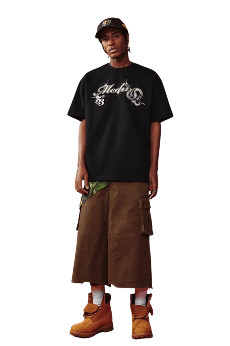 Model wearing MEDM SS25 Snake Year Limited Edition Tee with cargo shorts and stylish boots