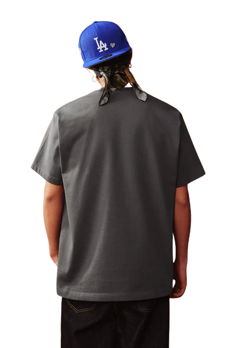 Back view of the MEDM SS25 Snake Year Limited Edition Tee in gray, worn by a model with a blue cap