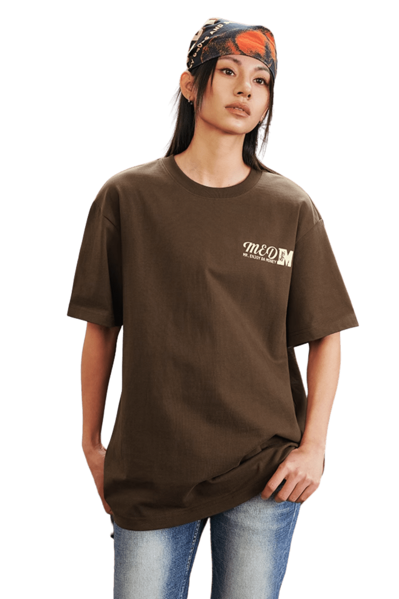 Model wearing the MEDM SS25 The Time Basic Logo Tee in brown for a stylish casual look