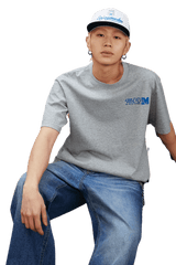 Model wearing MEDM SS25 The Time Basic Logo Tee in gray paired with casual jeans for a trendy look