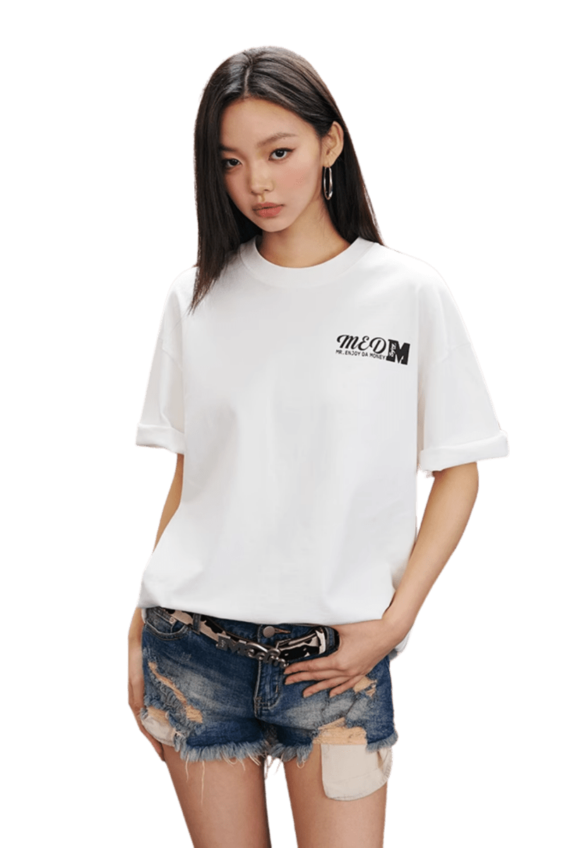 MEDM SS25 The Time Basic Logo Tee in White worn with distressed denim shorts for a casual look